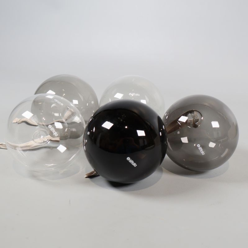 Närbild på julkulor i klara och rökiga glasnyanser