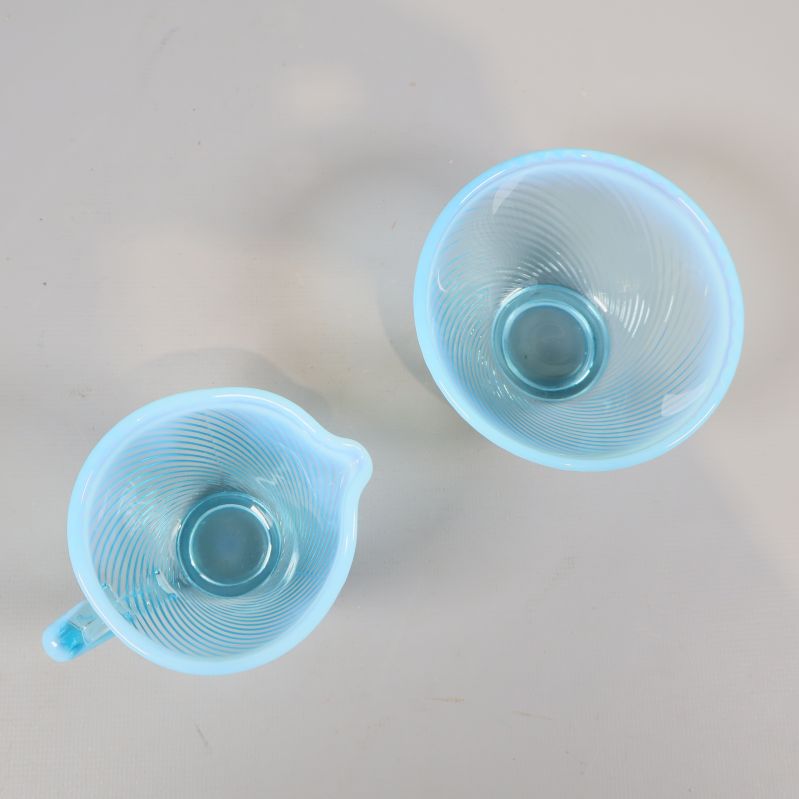 Ovanifrånvy av blå gräddkanna och sockerskål med spiralstruktur