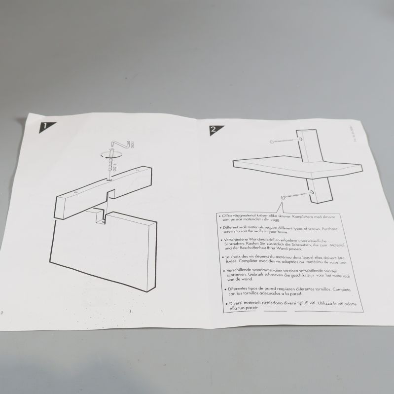 Uppslagen manual visar monteringsanvisningar för hylla