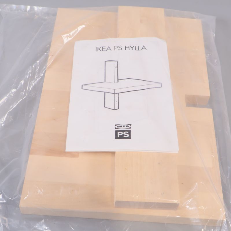 Hylla i ljust trä och manual i plastpåse