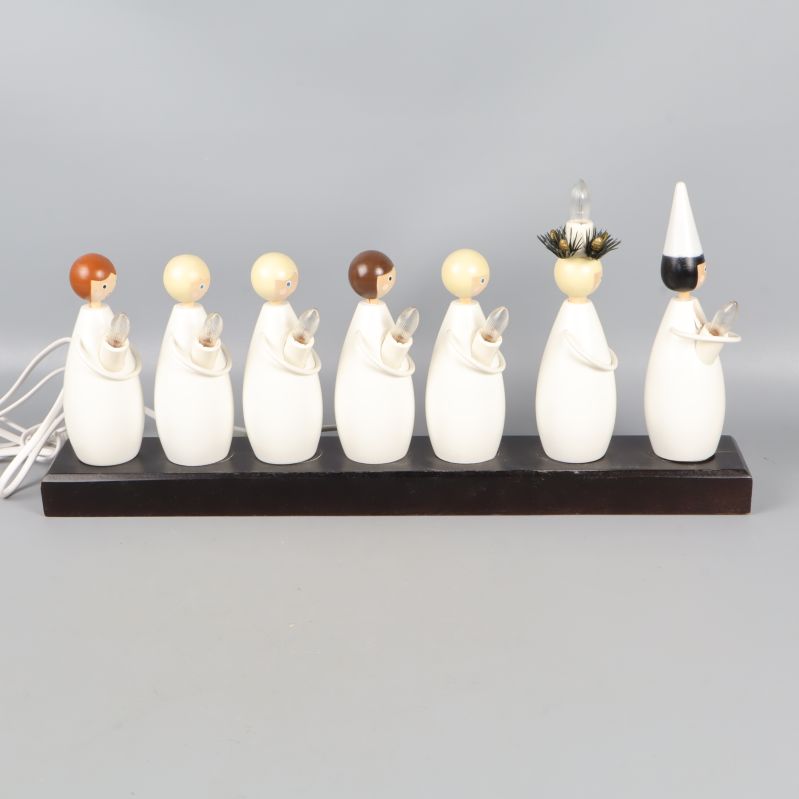 Luciatåg ljusstake med sju vita figurer på rad