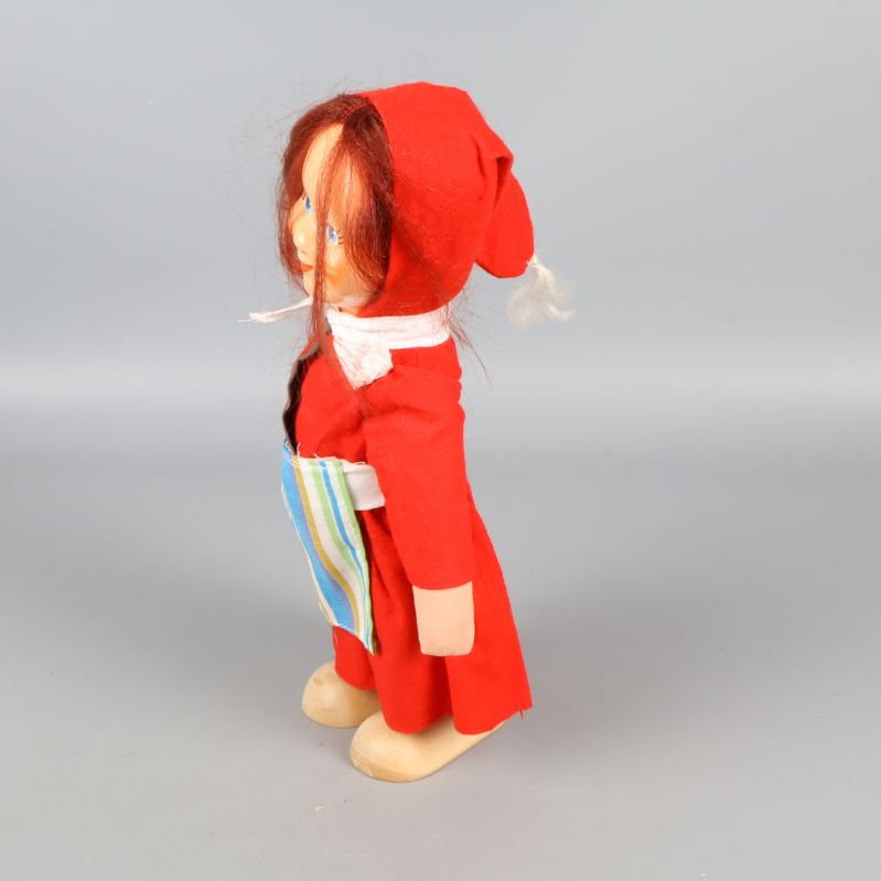 Tomteflicka i profil med randigt förkläde synligt