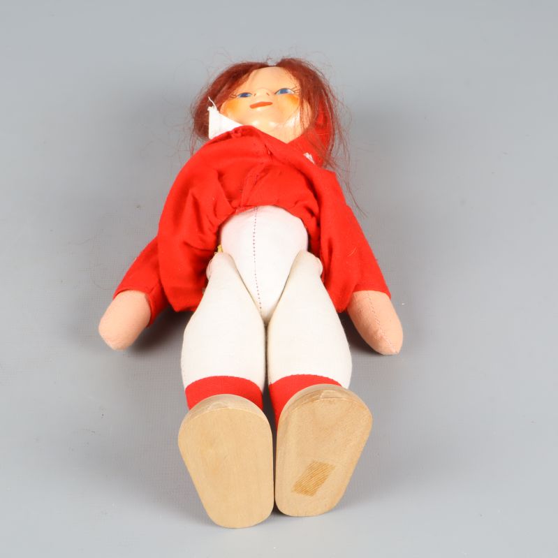 Tomteflicka liggande med vita byxor synliga