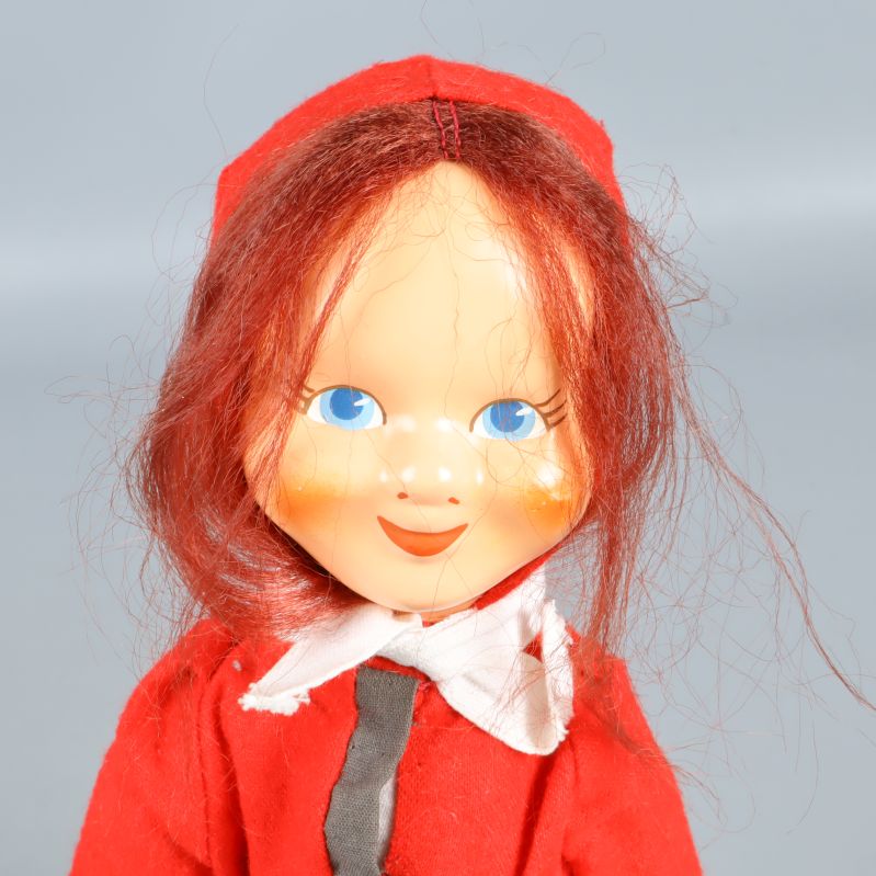 Närbild på tomteflickans ansikte med blå ögon och rött hår