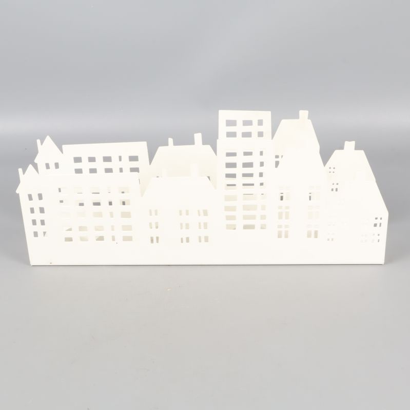 Ljuslykta i vit metall formad som stadssiluett