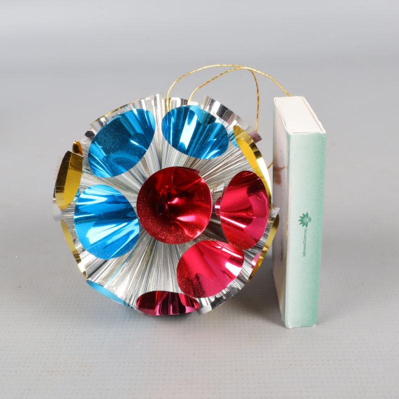 En rund, glansig juldekoration bredvid ask