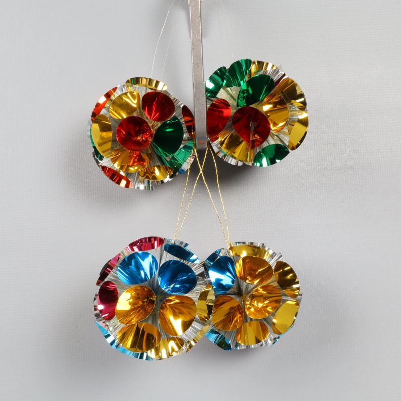 Fyra metallicfärgade juldekorationer hängande tillsammans