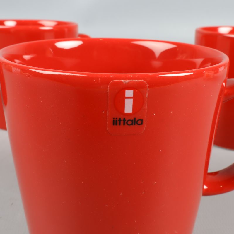 Närbild på röd mugg med iittala-logga framtill