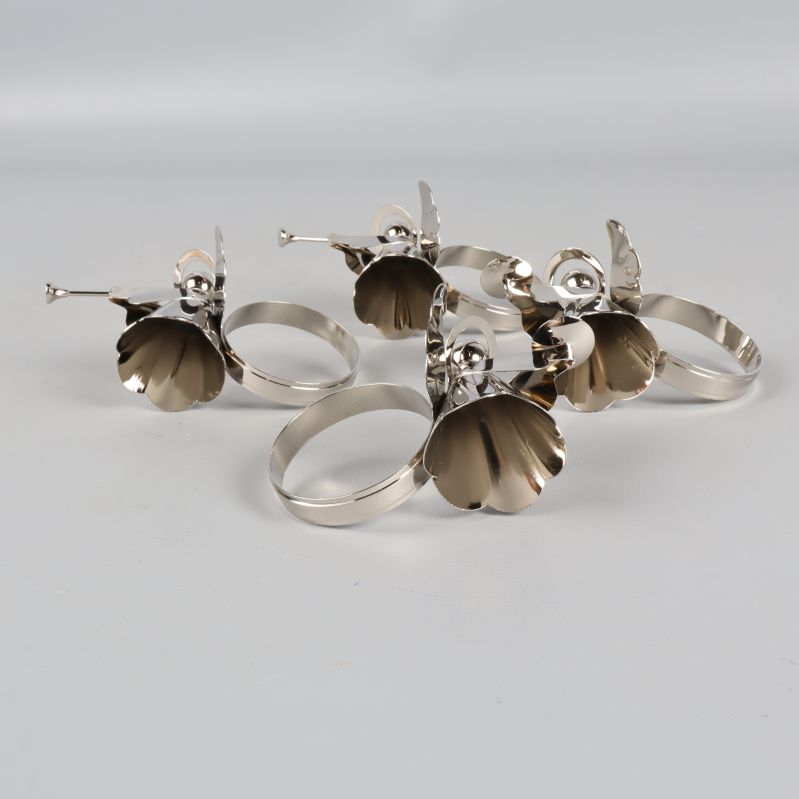 Bottenvy av fyra ängel-servettringar i metall