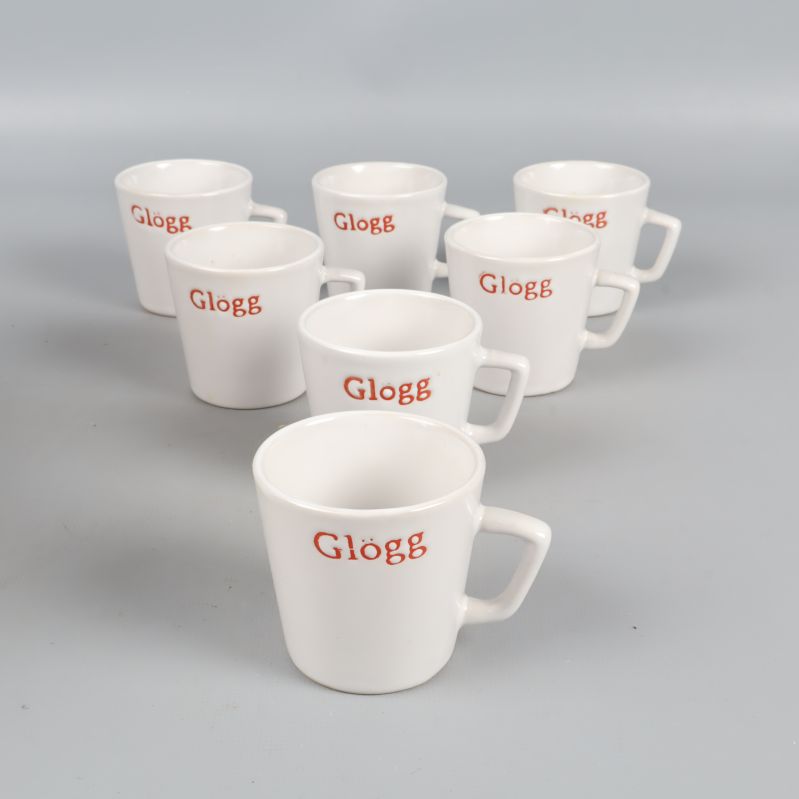 Sex vita glöggmuggar på rad med röd text