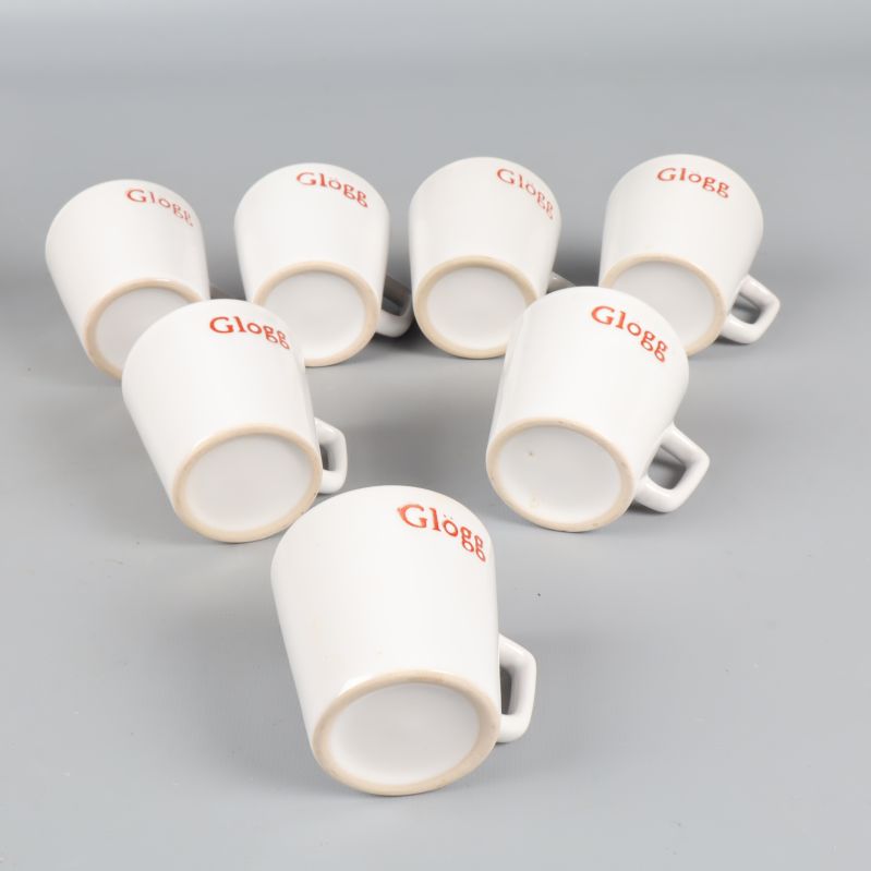 Sju vita muggar med röd text 'Glögg' placerade på sidan