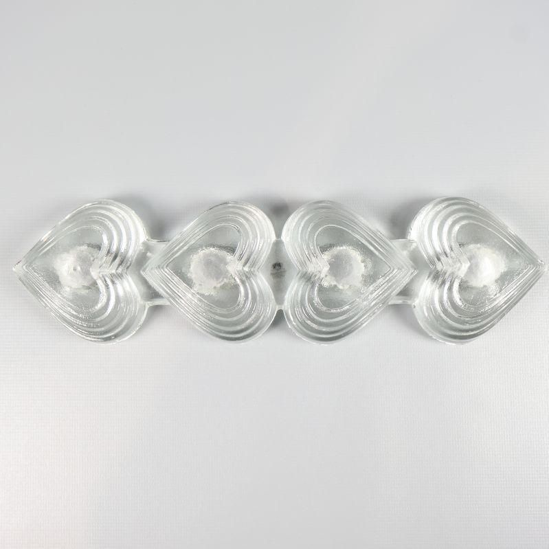 Ljusstake i glas med fyra symmetriska hjärtan sedd ovanifrån