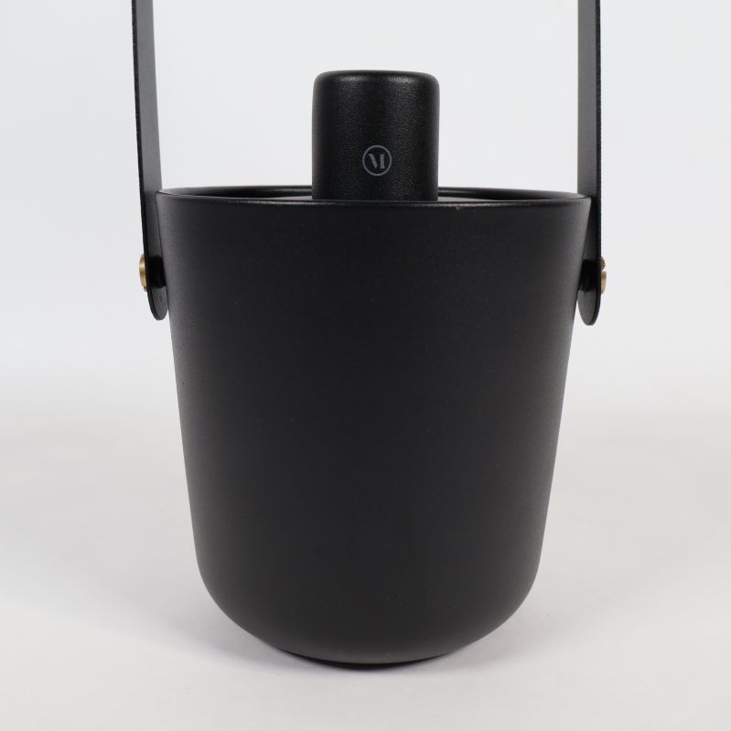 Närbild på eldykta i svart med lock och handtag