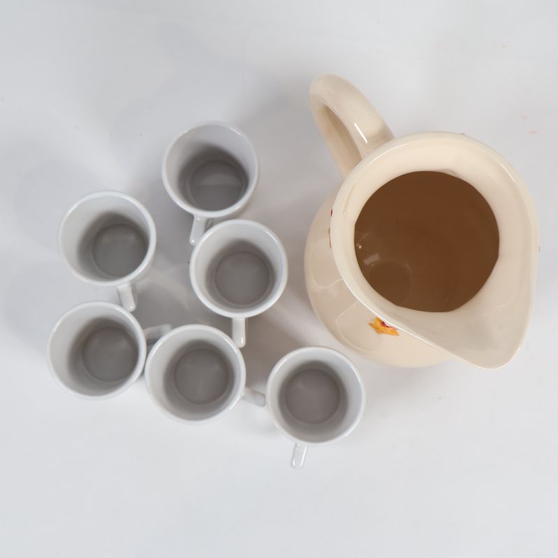 Uppifrånvy av kanna och sex vita glöggmuggar