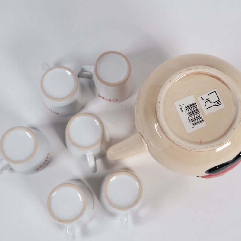 Kannans botten med etikett samt sex vita glöggmuggar