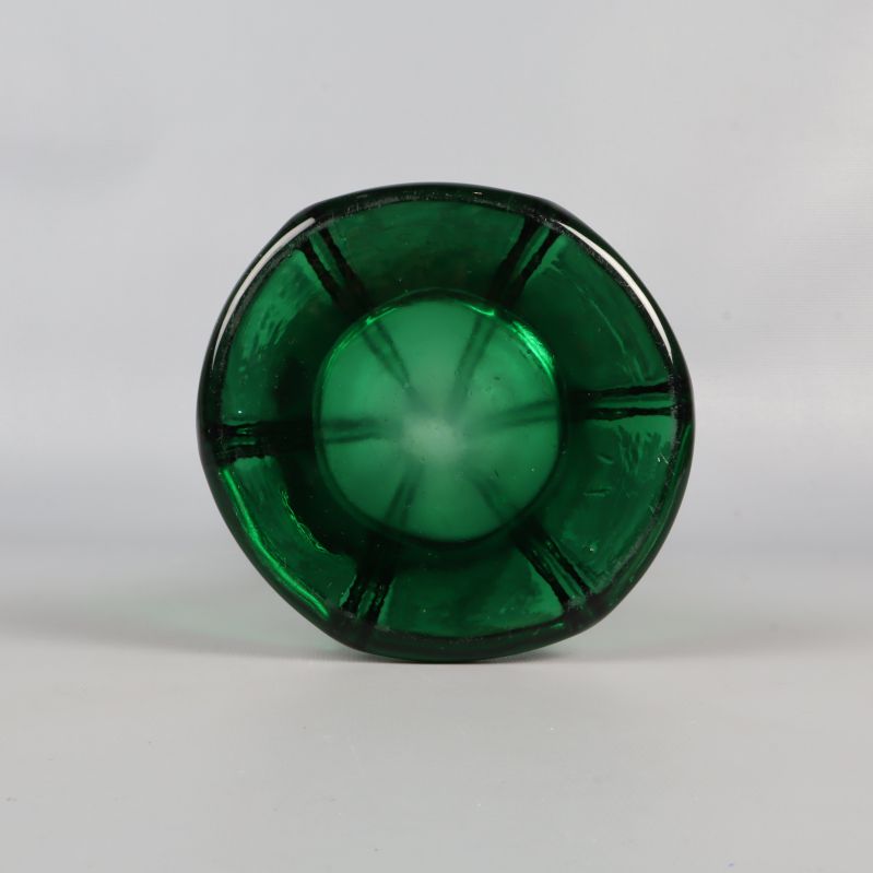 Bottenvy av grön glasvas med tydliga linjer