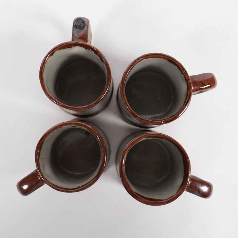 Top view på fyra små bruna och vita keramikmuggar