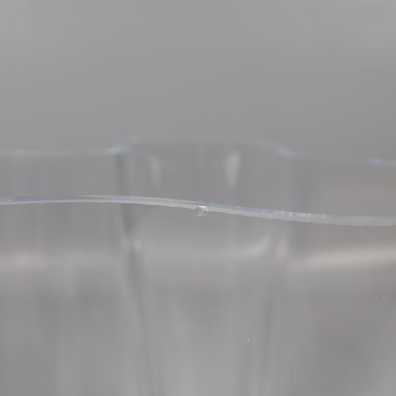 Närbild på liten nagg i glasvasens kant