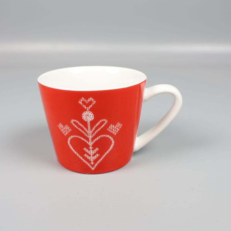 Röd glöggmugg med vitt hjärtmönster och handtag