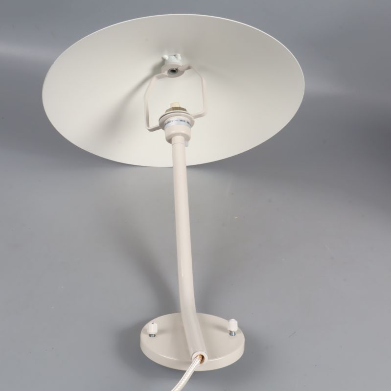 Vägglampa med rund fot och bred skärm sedd bakifrån