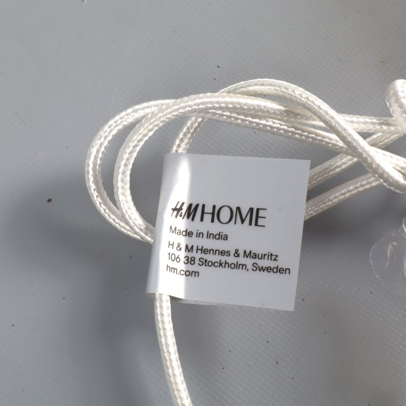 Etikett som visar H&M Home och tillverkningsinformation