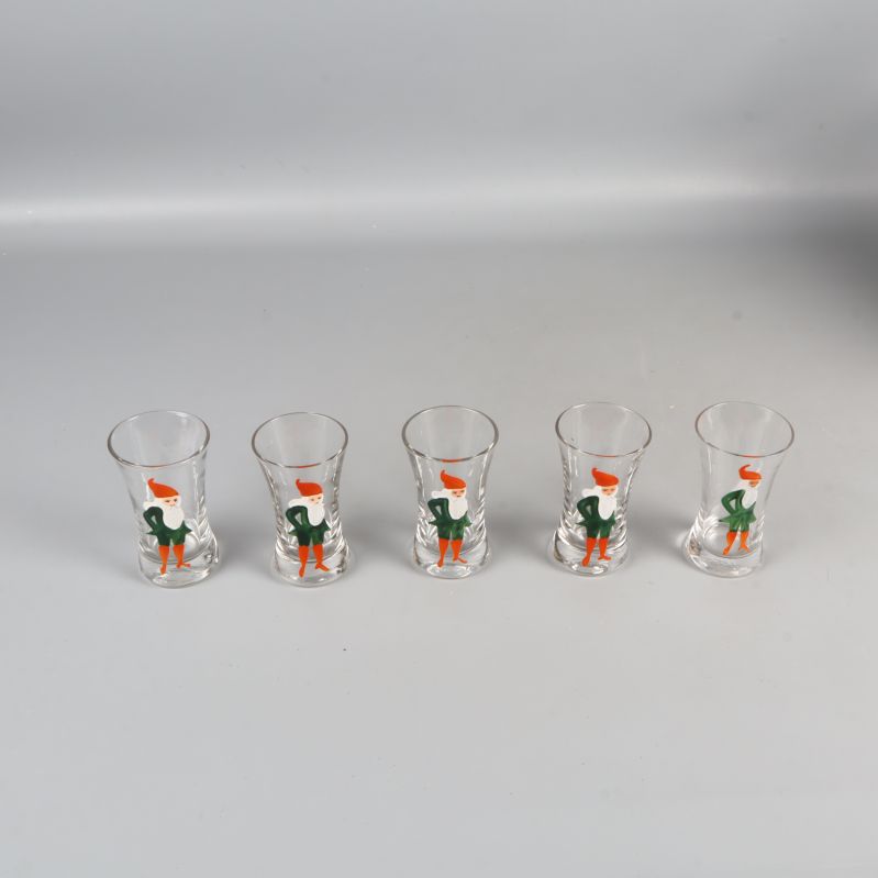 Fem snapsglas med tomtemotiv sedd ovanifrån