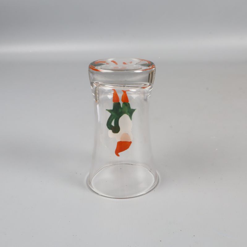 Snapsglas med tomtemotiv liggande upp och ner