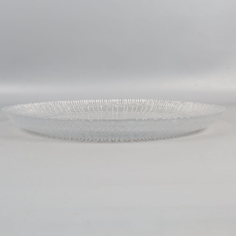 En stor transparent tallrik av glas från sidan