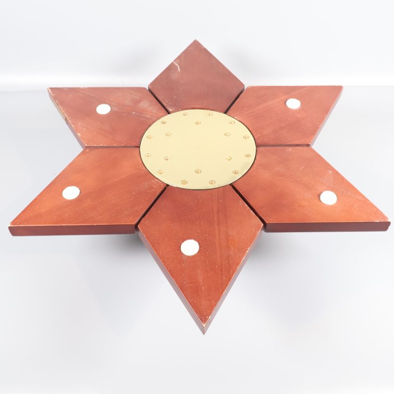 Undersidan av stjärnformad julgransfot med metallplatta och hål