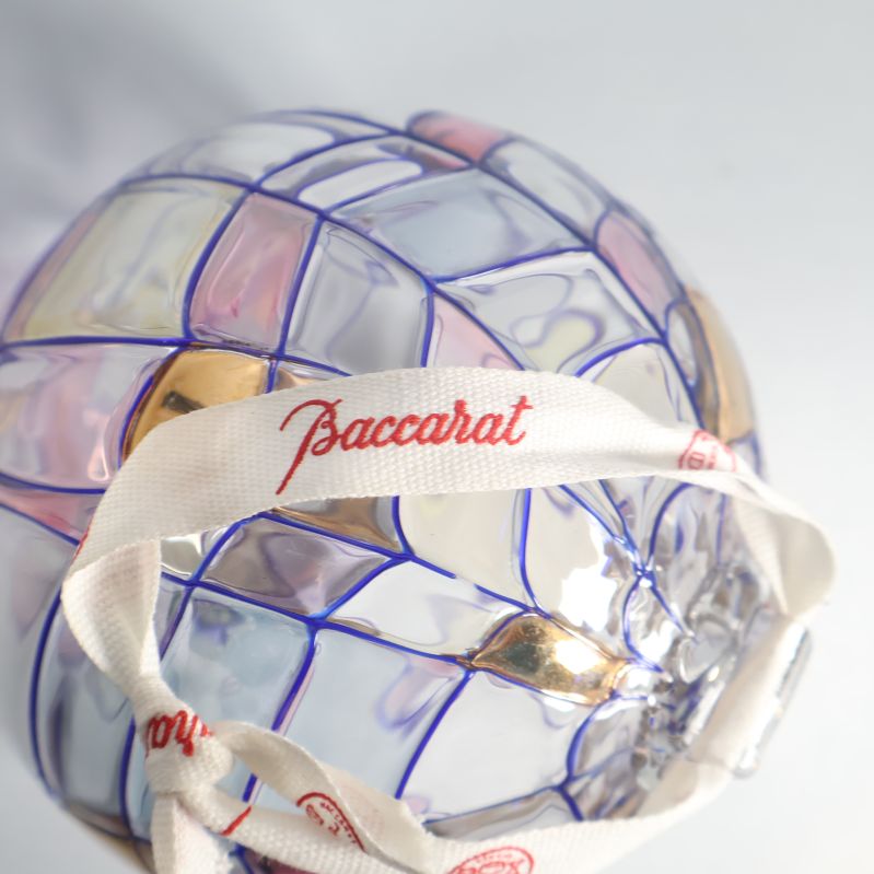 Närbild på glaskulans band med Baccarat logotyp och färgdetaljer
