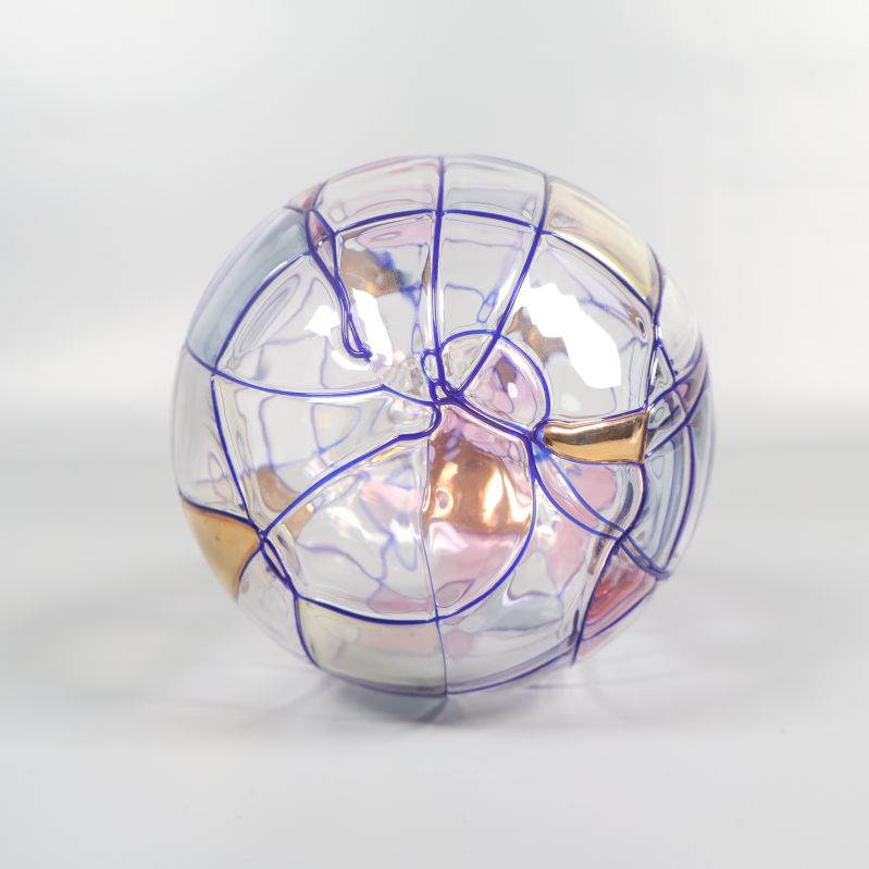 Glaskula med blåa linjer och färgade fält mot ljus bakgrund