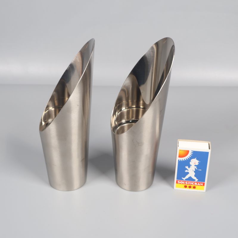 Två ljusstakar i metall bredvid tändsticksask