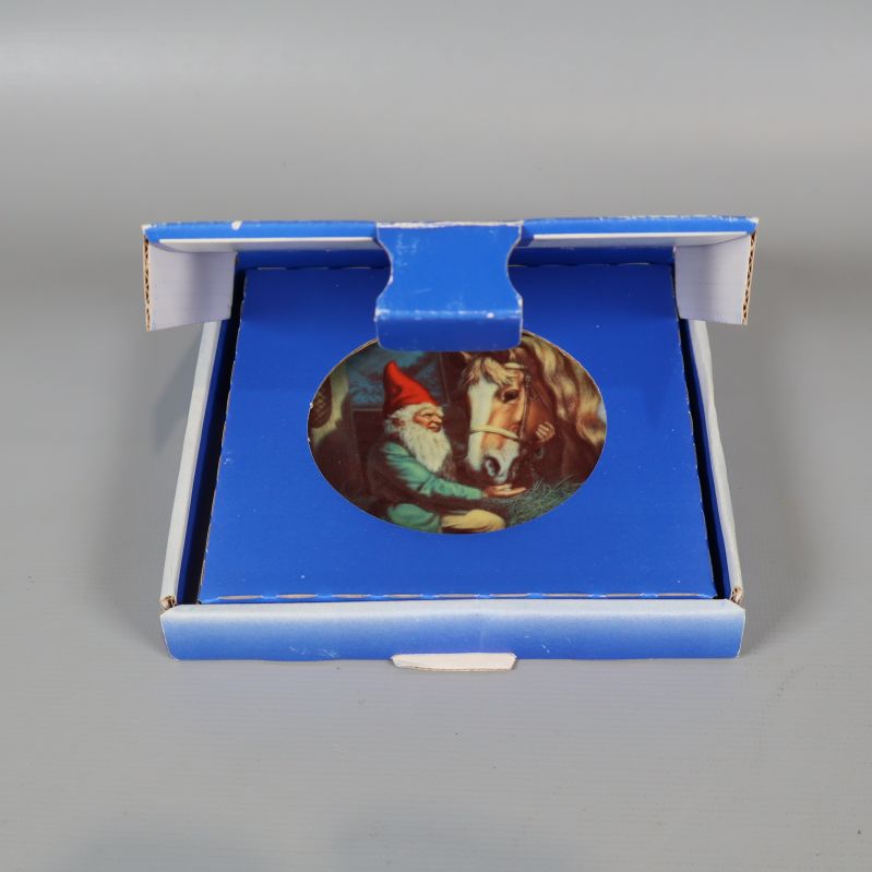 Tallrik med tomtemotiv i öppen blå kartong
