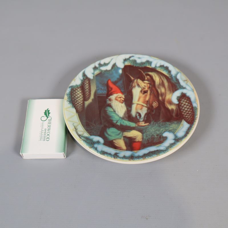 Jultallrik med tomtemotiv placerad bredvid en tändsticksask