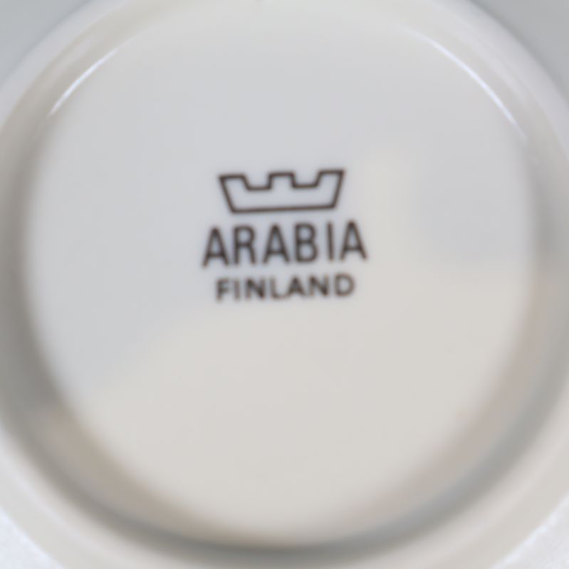 Närbild av stämpel Arabia Finland på vit tallrik