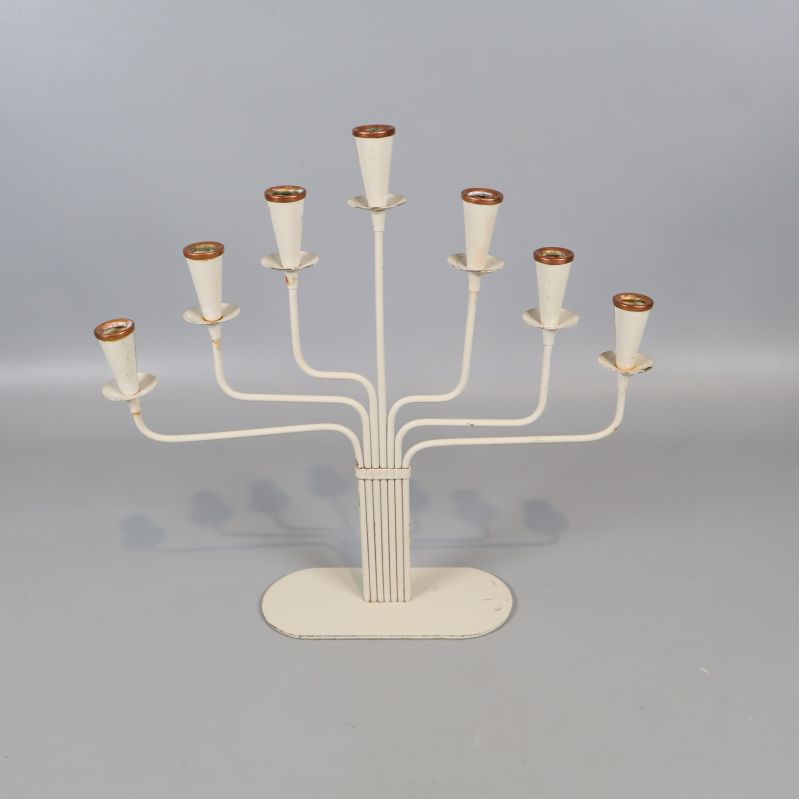 Vit sjuarmad ljusstake stående på grå bakgrund