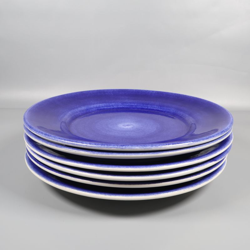 Sex blå mattallrikar prydligt staplade på varandra
