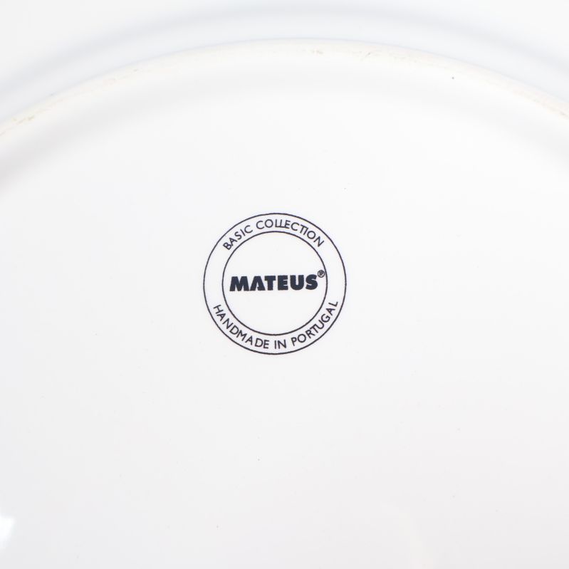 Närbild på Mateusstämpel och kollektionsmärkning på en tallrik