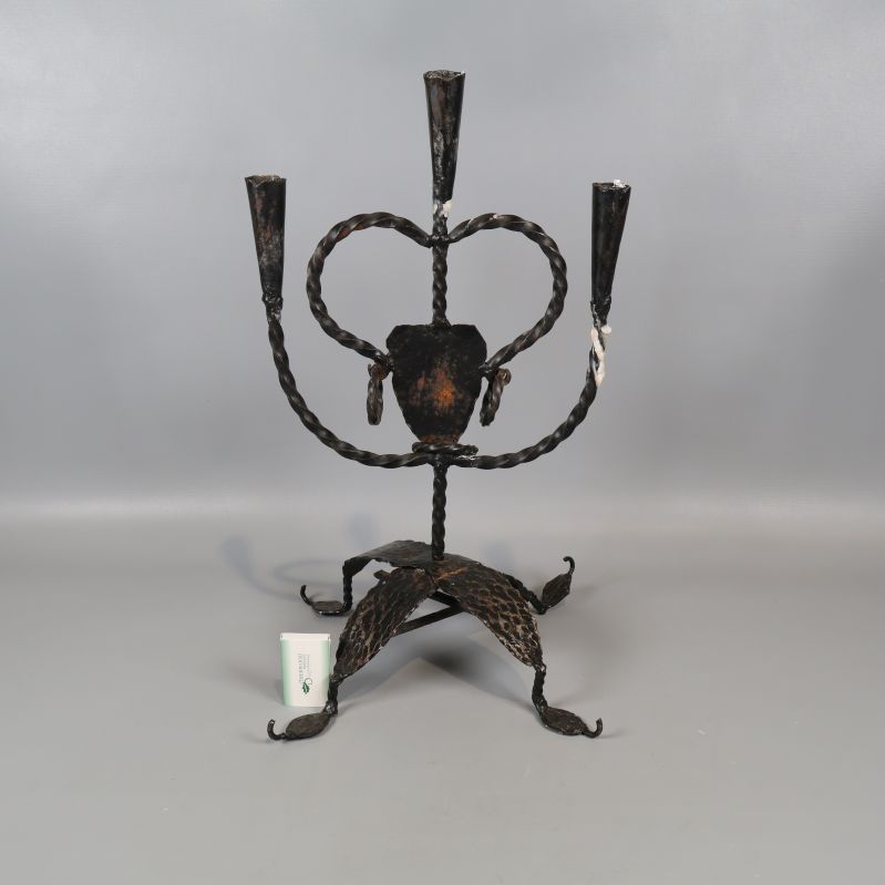 Smidesljusstake med tre armar och föremål för storleksreferens