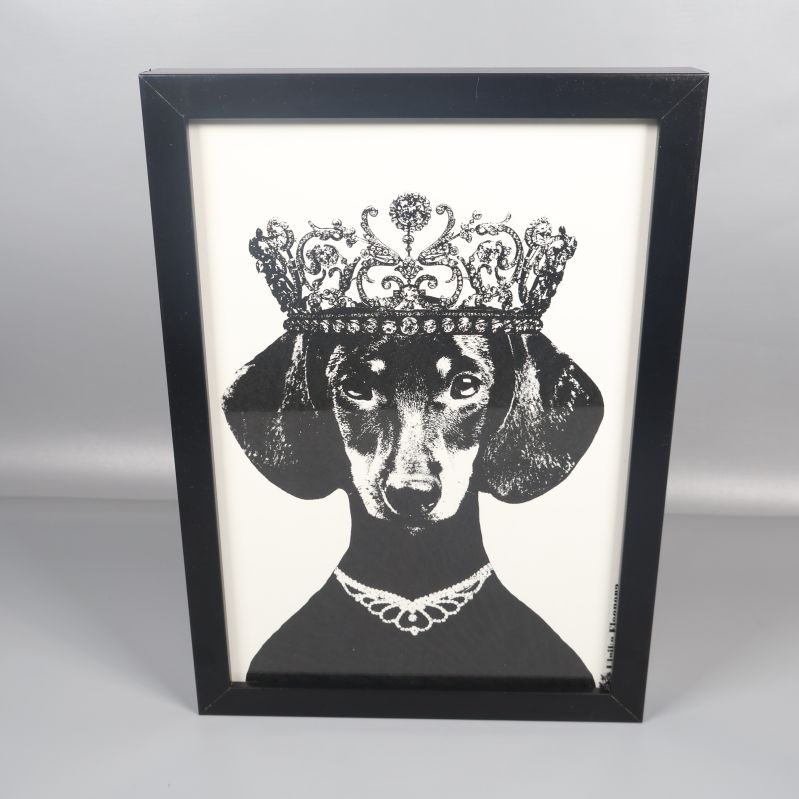 Tavla i svart ram med tax och krona som motiv