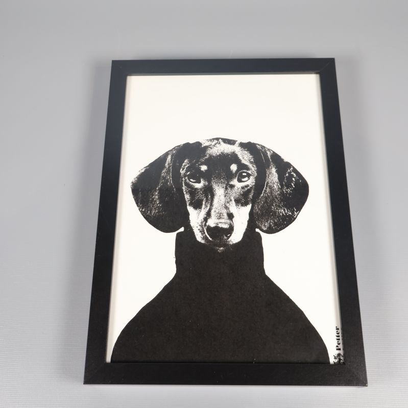 Tavla med hundmotiv liggande på yta