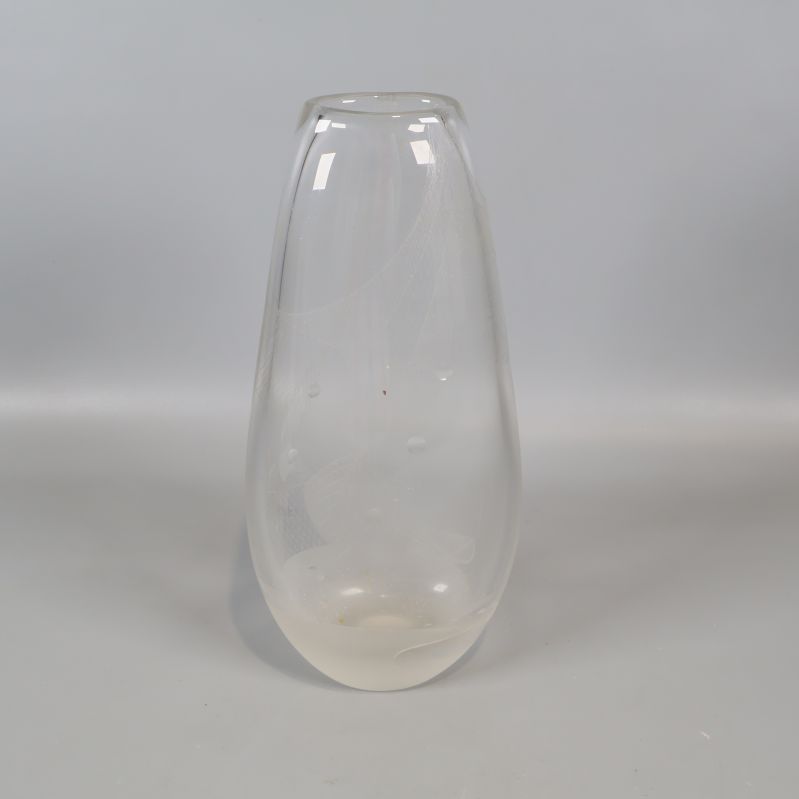 Stor transparent vas med rundad form mot grå bakgrund