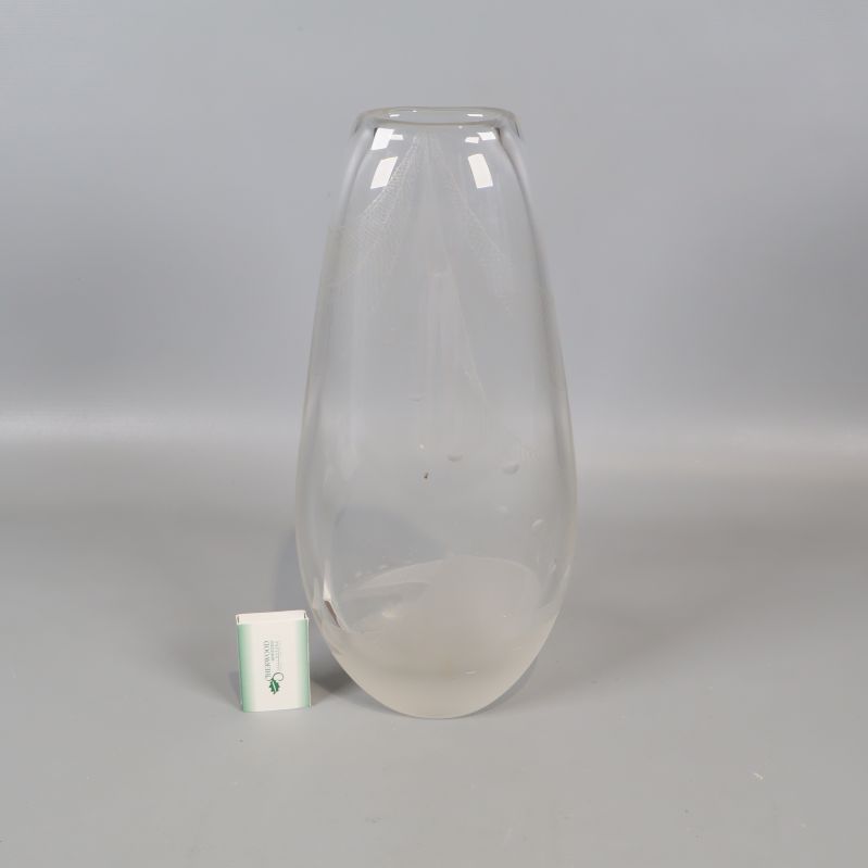 Transparent vas bredvid en liten tändsticksask för storleksjämförelse