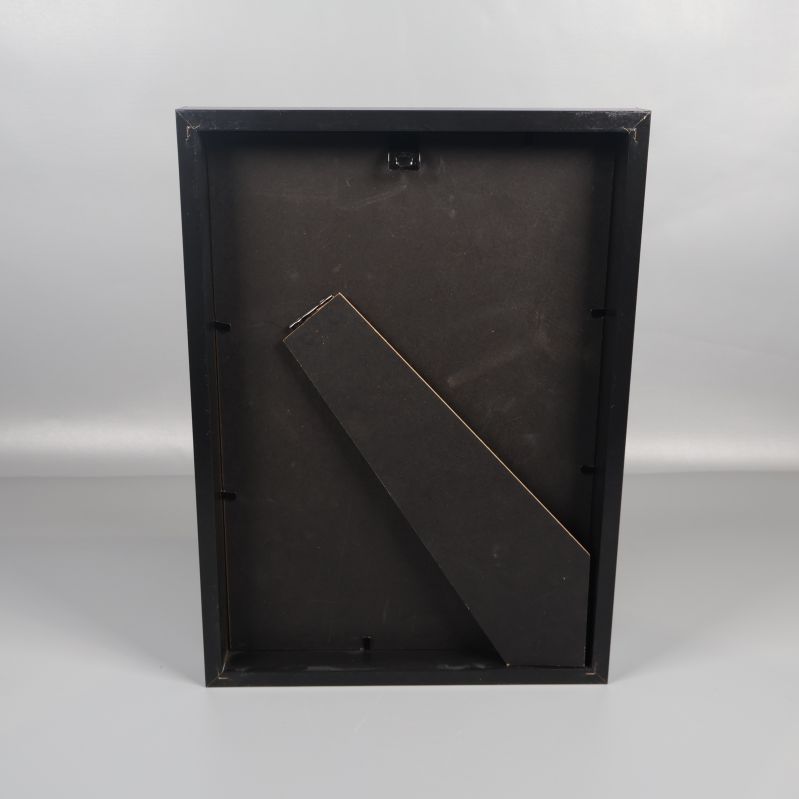 Baksidan av tavlan i svart med stödben