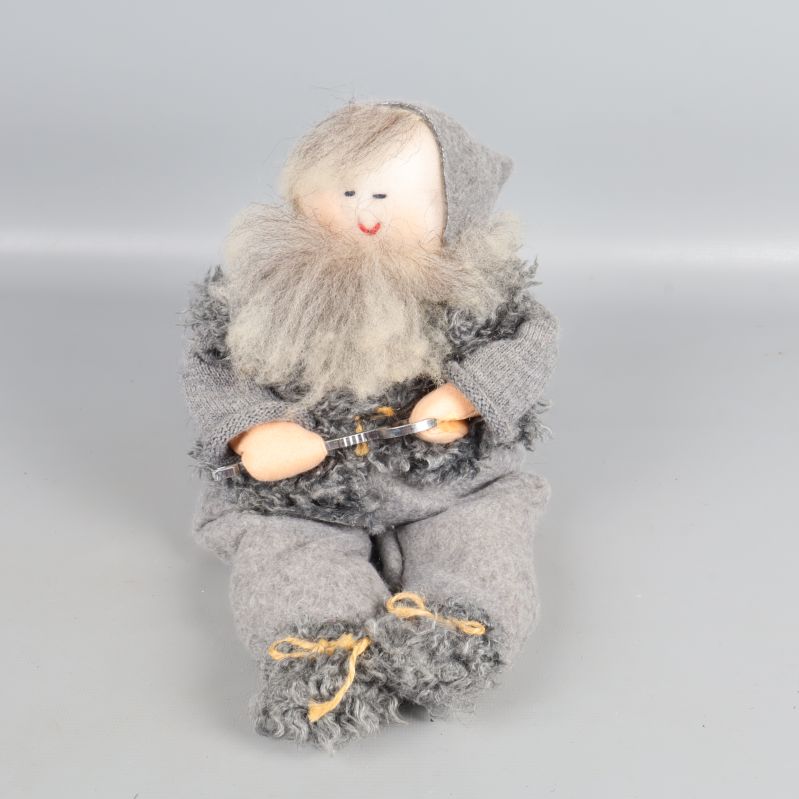 Närbild på tomtefigur med grått skägg och textilkläder