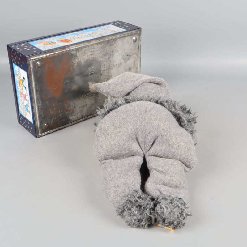 Tomtefigur liggande med baksidan upp, burkens undersida synlig