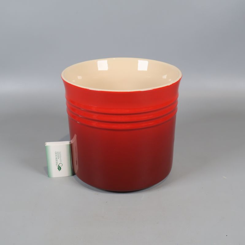 Röd Le Creuset-kruka med tändsticksask bredvid för storleksjämförelse