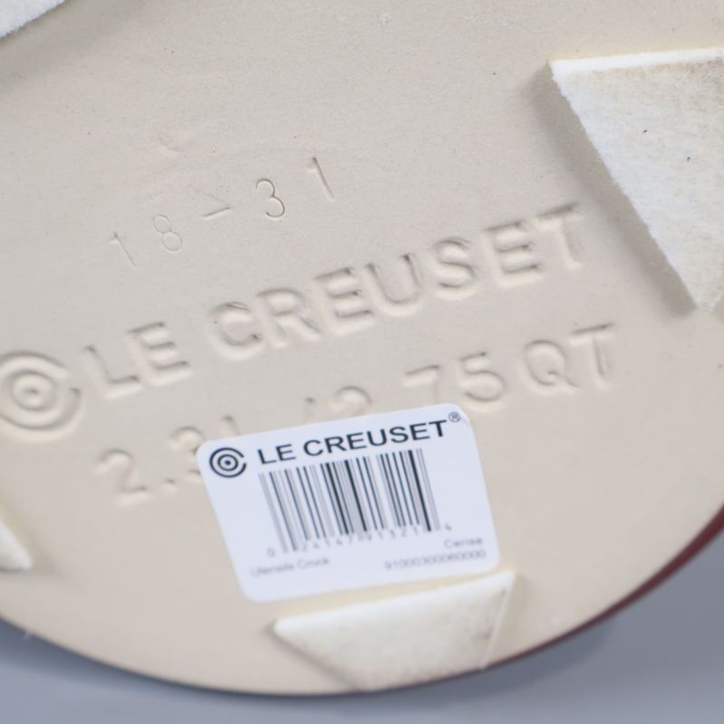 Närbild av botten med Le Creuset-text och etikett med streckkod