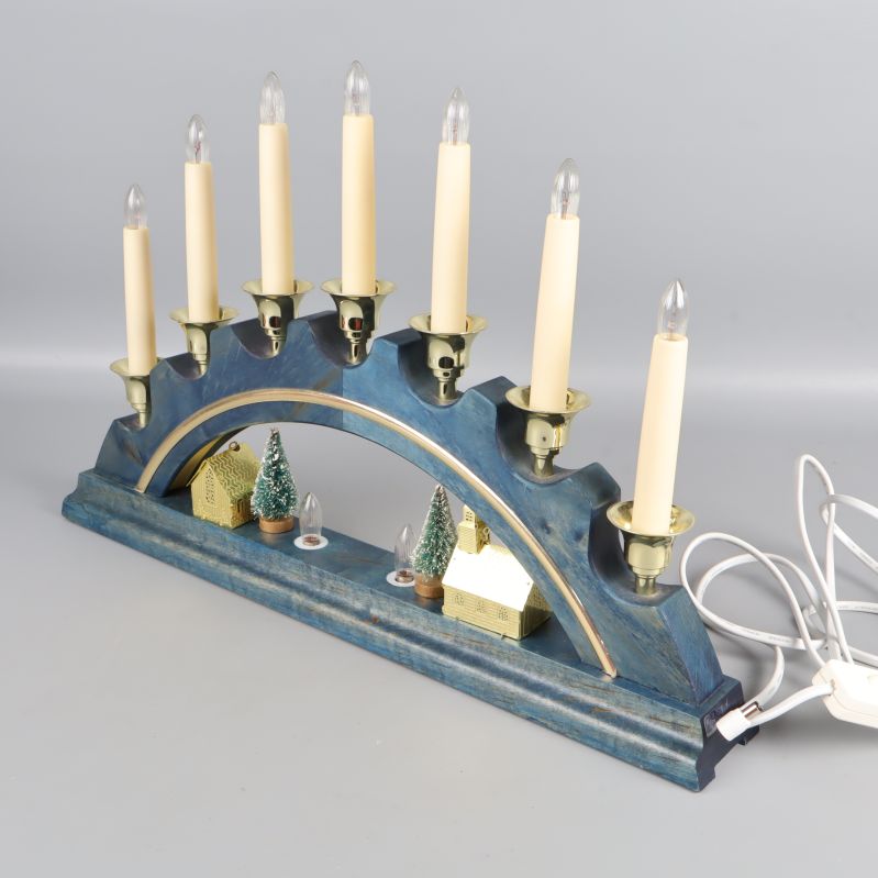 Adventsljusstake i blått trä sedd snett framifrån med dekorationer