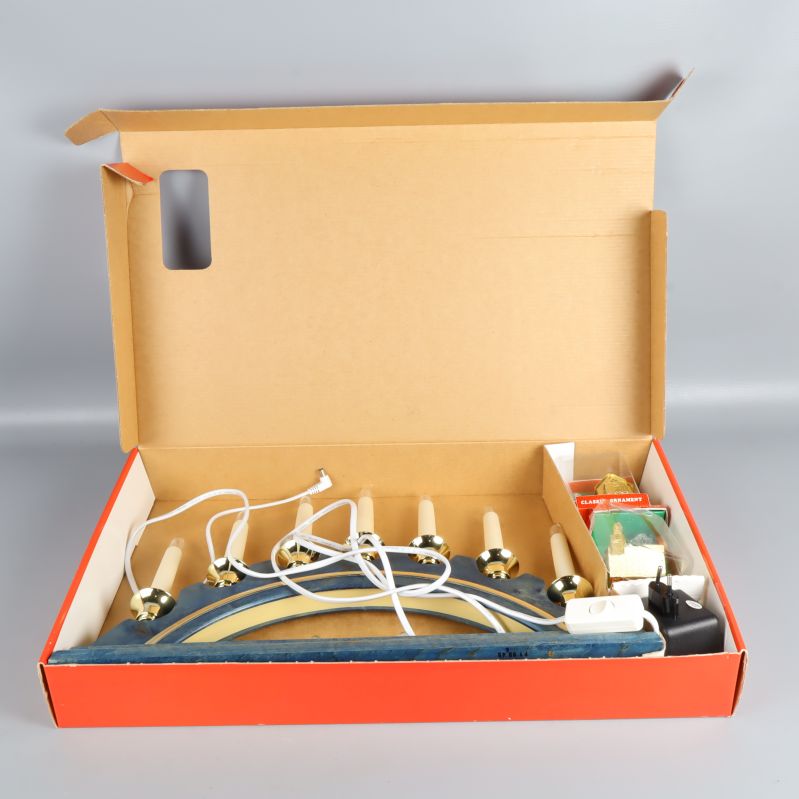 Adventsljusstake nedpackad i öppen kartong med tillbehör